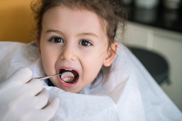 Dentist examining a young patient's teeth.